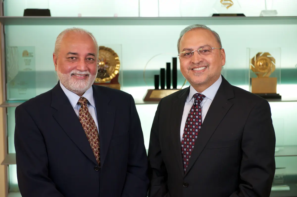 Two men in suits smiling