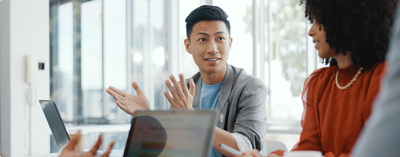 Team talking in office with laptops open